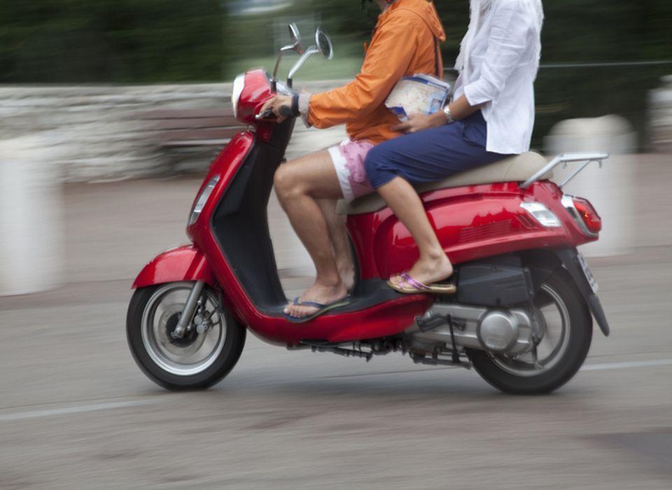 Ludzie na czerwonym skuterze